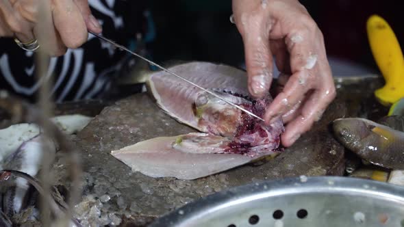 Woman Is Cutting Fish at a Seafood Market