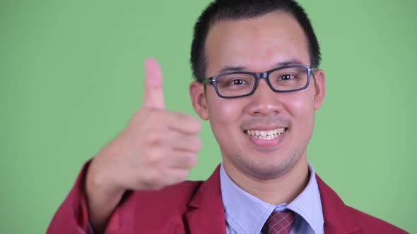 Face of Happy Asian Businessman with Eyeglasses Giving Thumbs Up