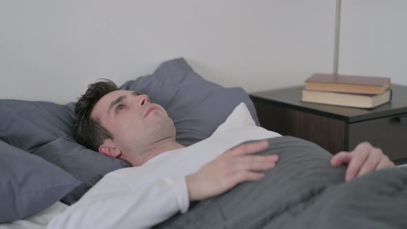 Man Laying in Bed Unable to Sleep