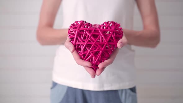 Girl Holding a Wickerwork in the Shape of a Heart