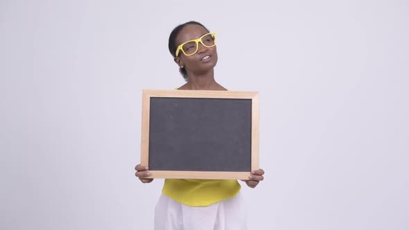 Happy Young Beautiful African Woman Holding Blackboard and Thinking