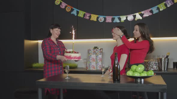 Mother Bringing Sparkler Cake at Birthday Party