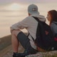 A Guy and a Girl are Sitting on Top of a Mountain and Enjoying the Landscape - VideoHive Item for Sale