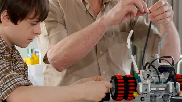 Senior Man and His Grandson Assembling Toy Vehicle