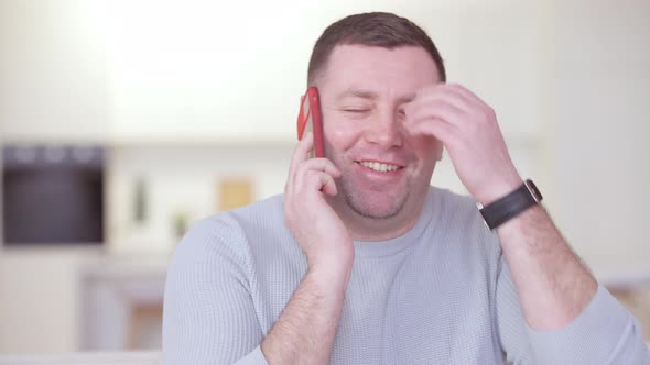 Portrait of Brunette Cheerful Adult Man Talking on the Phone Laughing