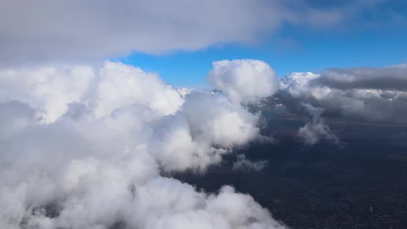 Aerial View From Airplane Window at High Altitude of Earth Covered with White Puffy Cumulus Clouds