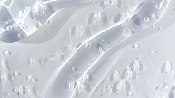 Transparent Cosmetic Gel Fluid Flowing Down on a White Surface