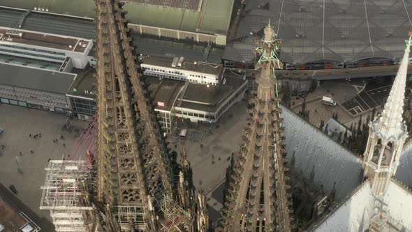 AERIAL: Close Up Overhead Circle Around Cologne Cathedral Brown Towers in Beautiful Sunlight 