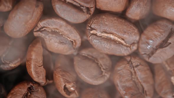 Close Up of Seeds of Coffee. Fragrant Coffee Beans Are Roasted Smoke Comes From Coffee Beans.