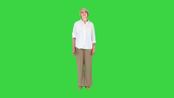 Aged Woman in White Shirt Standing Doing Nothing on a Green Screen Chroma Key