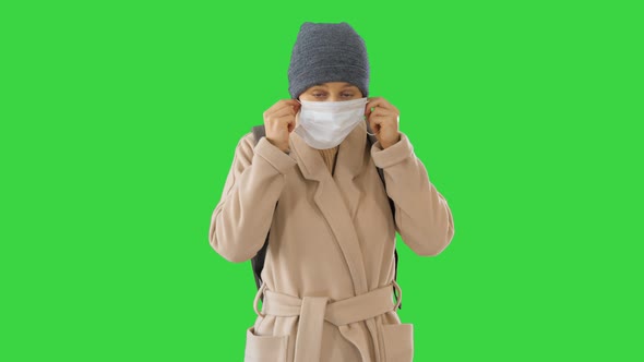 Blonde Woman Walking and Putting Face Protection on in Prevention for Coronavirus Covid 19 on a