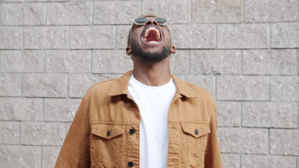 Endless Loop of Excited AfroAmerican Student Nodding Head and Laughing Outdoors