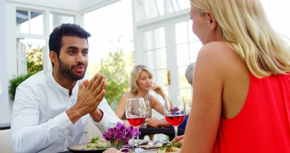 Couple interacting while having red wine in restaurant