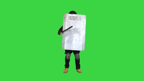 Special Unit Policeman Covering with a Shield and Holding a Baton on a Green Screen Chroma Key