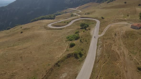 Aerial view of a man driving a motorbike on a mountain road