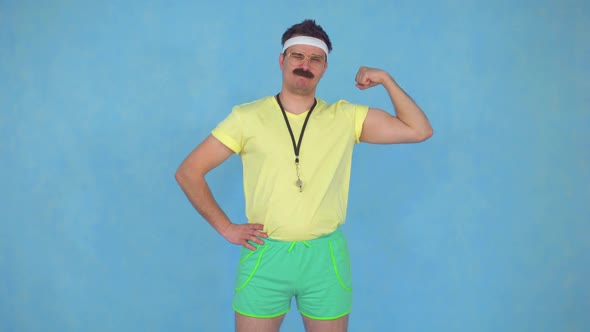 Funny Young Male Coach with a Mustache From 80's Shows His Muscles and Kisses Them