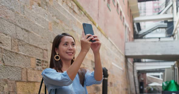 Woman tourist take photo on cellphone and visit old landmark in Hong Kong