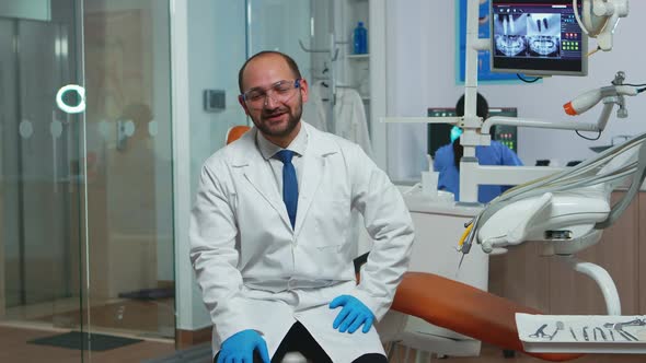 Dentist Doctor Looking at Camera Talking with Patients