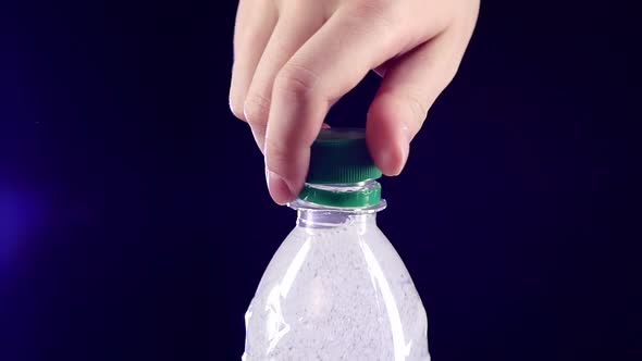 Hands Opening a Green Bottle of Fresh Water on Dark, Slow Motion, Splash, Spray, Bubbles