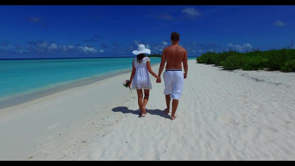 Man and woman posing on exotic coastline beach adventure by clear ocean and white sandy background o