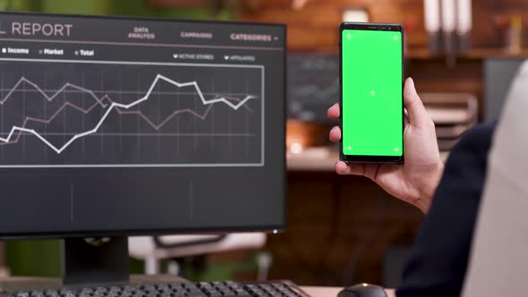 Back View of Businessman Working on Mobile Phone with Green Screen