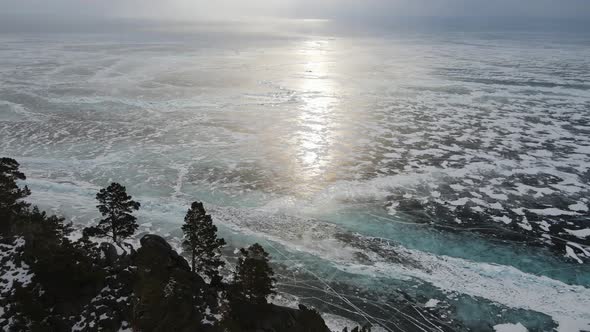 A snowstorm on Lake. Gusts of wind sweep snow away and reveal ice shiny surface