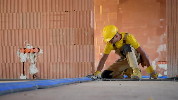 Construction Worker Finishing Interior Electric Floor Installations