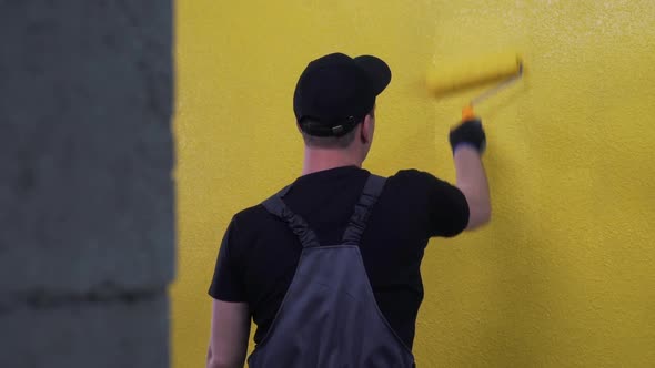 Worker Paints a Wall in Bright Colour