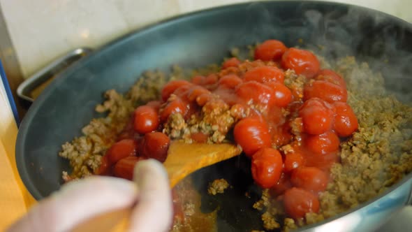 Mix the Ingredients for the Chorizo and the Preserved Tomatoes with a Wooden Spoon