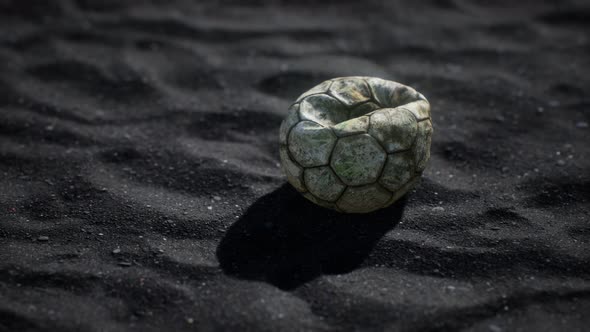 Old Football Ball on the Black Sand