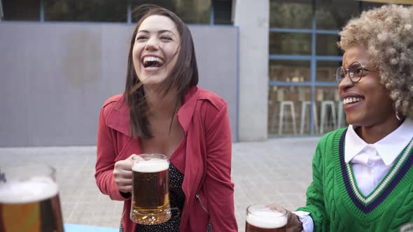 Carefree Friends Enjoying Drinking Together in Outdoors Bar