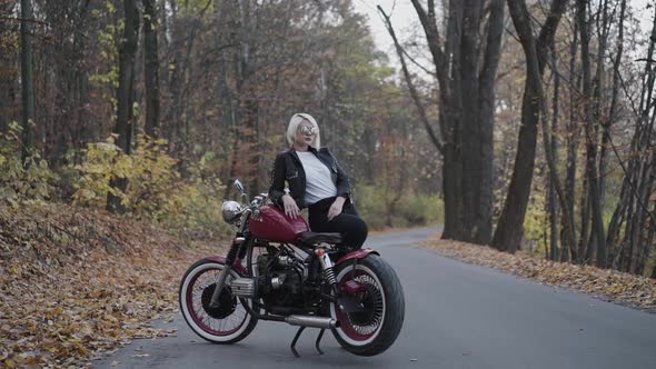 Brutal Biker Comes to His Lady Leaned on Motorcycle in Park