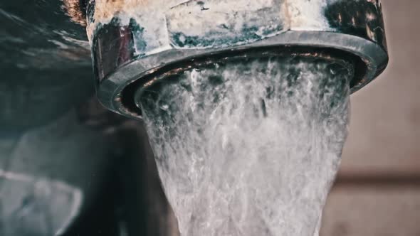 Water Flows From an Old Contaminated Tap with Calcium and Grime Into a Sink