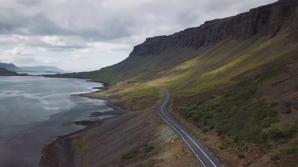 Peaceful icelandic landscape. Drone shot next to the road going between a valley and a lake. 4k with