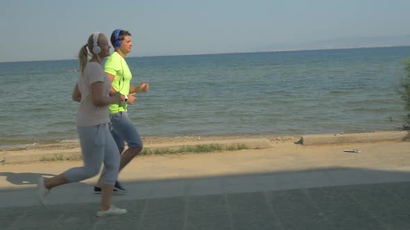 People in Headphones Jogging along the Esplanade