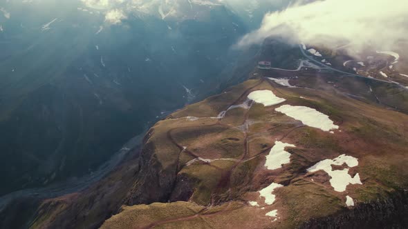 Birdseye View of Mountains with Clouds Small Lake in Distance