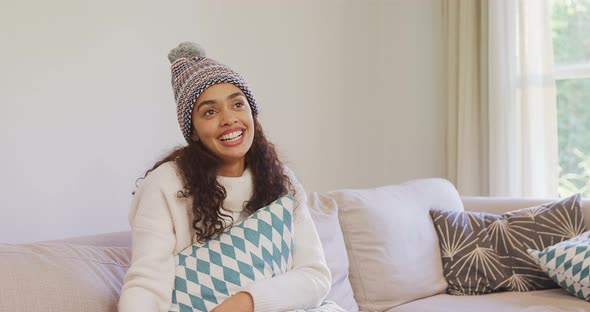 Happy woman in warm clothing sitting on sofa watching television 4K 4k