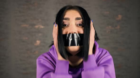 VERY Angry Young Woman Showing Emotions with Her Mouth Covered in Duct Tape