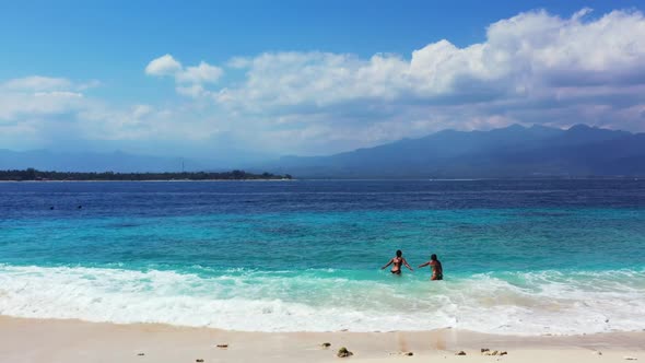 Girls tan on tropical lagoon beach time by aqua blue sea and bright sand background of Bali near sur