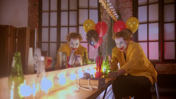 A Depressed Crying Man Clown Smoking and Drinking in the Dressing Room After Working