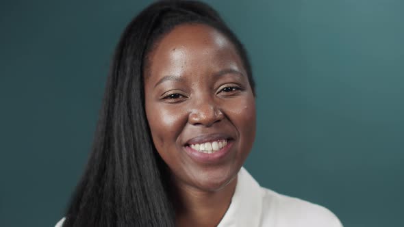 Black Female with Long Hair Posing Over Green Studio Background Smiling