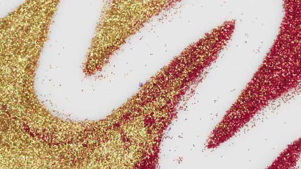 Gold and Red Glitter on White Background Gloss Golden Powder Closeup