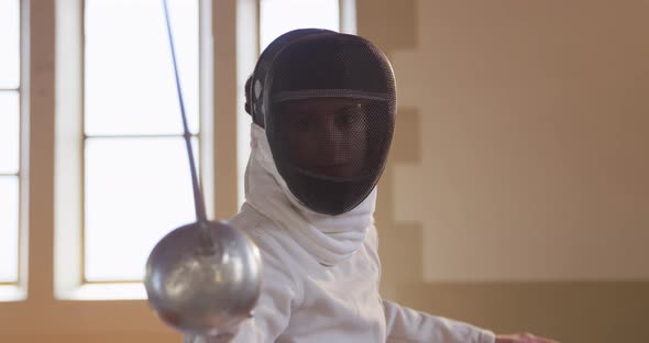 Female fencer athlete during a fencing training in a gym