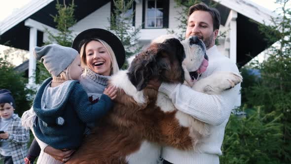 Happy Family with Their Big Dog Near the House in Nature