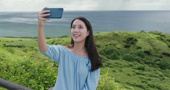Woman take photo on cellphone in the countryside
