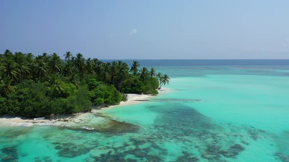 Wide overhead tourism shot of a paradise sunny white sand beach and blue sea background in vibrant 4