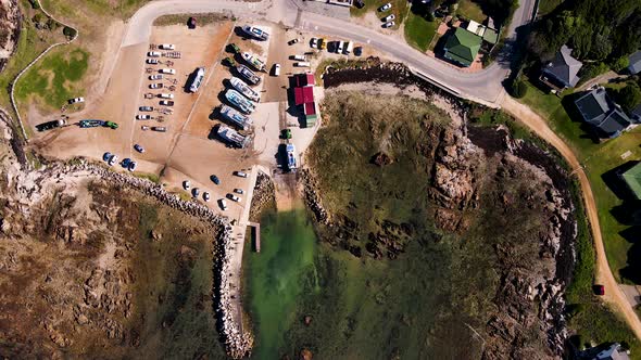 Rising drone shot reveals vessels at harbor used for shark cage diving industry