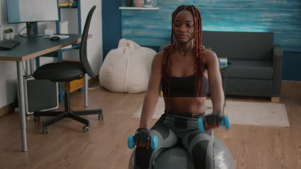 Athletic Black Woman Exercising Body Exercises with Yoga Dumbbells