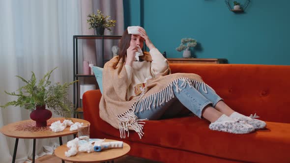 Portrait of Young Woman Suffering From Cold or Allergy in Plaid Lying on Sofa in Living Room at Home