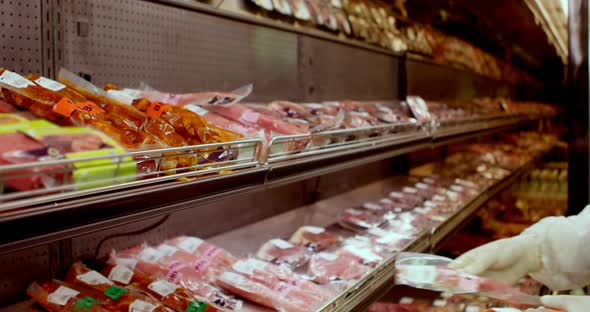 Butcher arranging wrapped meat in rack 